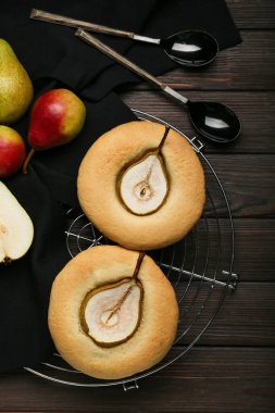 Lezzetli armutlu turtalar ve koyu ahşap arka planda taze meyveler.