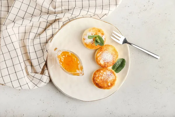 stock image Plate with tasty cottage cheese pancakes and jam on light background