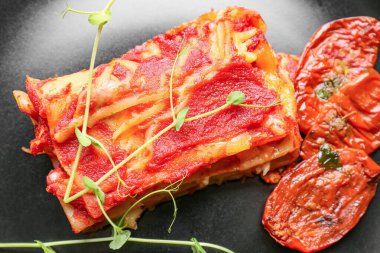 Tabakta domates sosu olan lezzetli bir lazanya, yakın plan.