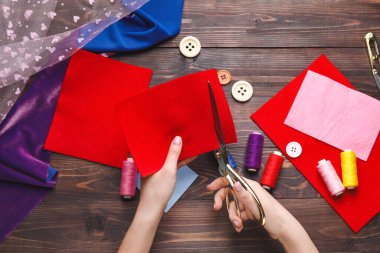 Kesen kadın koyu tahta arka planda keçeleşiyor