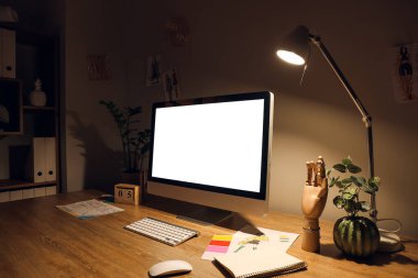 Karanlık odada bilgisayarı olan modern işyeri