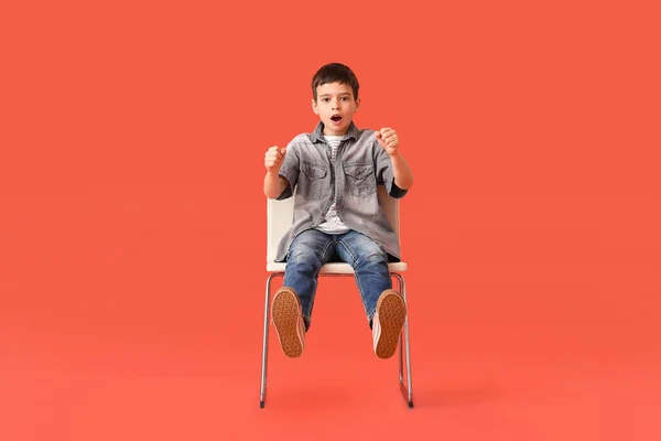 Zszokowany Chłopczyk Wyimaginowanym Kierownicą Siedzący Krześle Kolorowym Tle — Zdjęcie stockowe