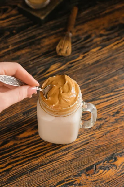 Woman Stirring Tasty Dalgona Hojicha Latte Wooden Background — Stock Photo, Image