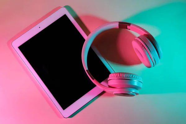 現代のタブレットコンピュータとヘッドフォンの色背景 — ストック写真