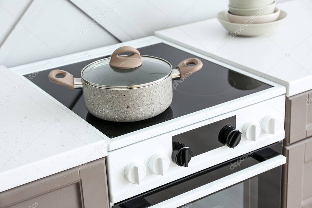 Modern oven with cooking pot in kitchen