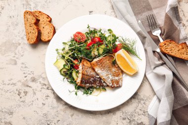 Lezzetli kızarmış morina filetosu, sebze ve hafif arkaplanda ekmek tabağı.