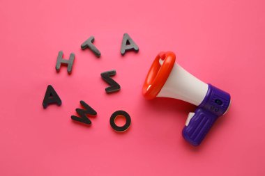 Oyuncak megafon ve renk arkaplanındaki harfler