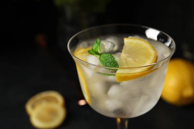 Karanlık arka planda bir bardak soğuk cin tonik, yakın plan.