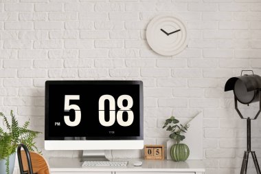 Tuğla duvarın yanında bilgisayarı olan modern işyeri