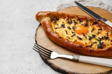 Hafif arka planda lezzetli Ajarian Khachapuri olan ahşap tahta, yakın plan.