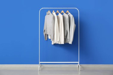 Renkli duvarın yanında kalın kazaklar var.