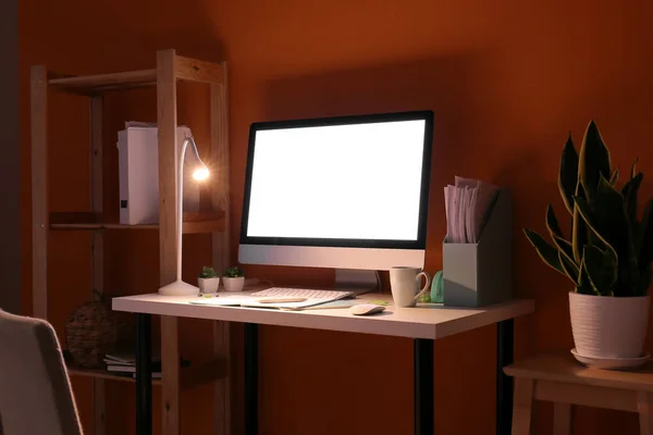 Modern Arbetsplats Med Dator Och Glödande Lampa Nära Färgvägg — Stockfoto