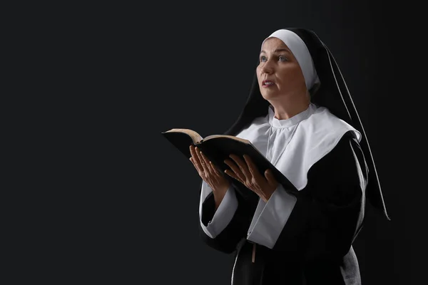 Madura Monja Leyendo Sagrada Biblia Sobre Fondo Oscuro — Foto de Stock