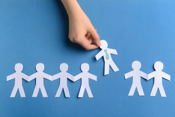 Женская рука и бумага человеческие фигуры на цветном фоне. Концепция увольнения