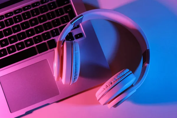 stock image Modern laptop and headphones on color background, closeup