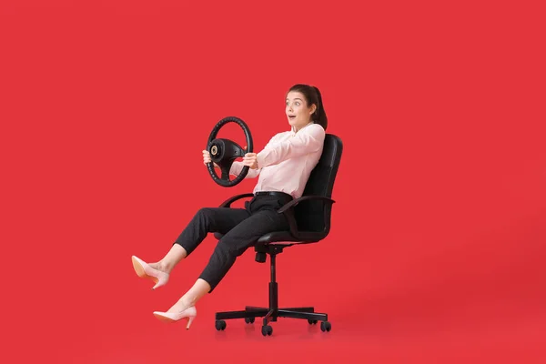 Surpreendida Jovem Empresária Com Volante Sentado Cadeira Sobre Fundo Cor — Fotografia de Stock
