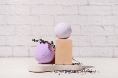 Banyo bombaları ve hafif tuğla duvarın yanında lavanta çiçekleri olan kompozisyon