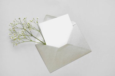 Boş kartla zarf ve açık arkaplanda çiçekler
