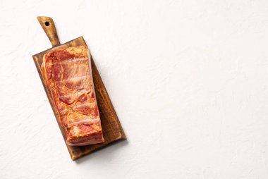 Hafif arka planda lezzetli tütsülenmiş pastırmalı ahşap tahta.