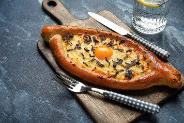 Renkli arkaplanda lezzetli Ajarian khachapuri olan tahta tahta tahta.