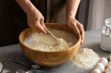 Kadın aşçı mutfak masasında hamur hazırlıyor, yakın plan.