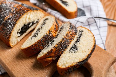 Ahşap zemin üzerinde dilimlenmiş haşhaş tohumu olan tahta, yakın plan.