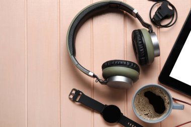 Farklı modern cihazlar ve renkli ahşap arka planda bir fincan kahve.