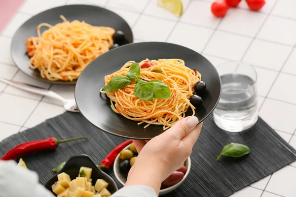 Woman Holding Plate Tasty Pasta Puttanesca Table Restaurant — Stock Photo, Image