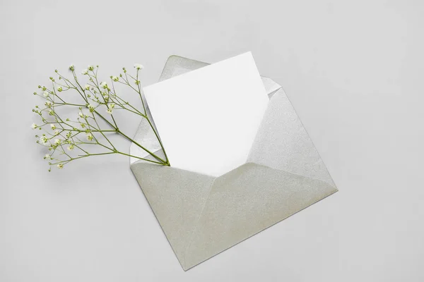 用空白卡片和浅色背景的花朵包裹的信封 — 图库照片