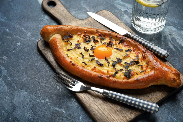 Renkli arkaplanda lezzetli Ajarian khachapuri olan tahta tahta tahta.