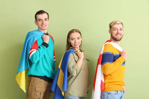 Jóvenes Con Diferentes Banderas Sobre Fondo Color — Foto de Stock