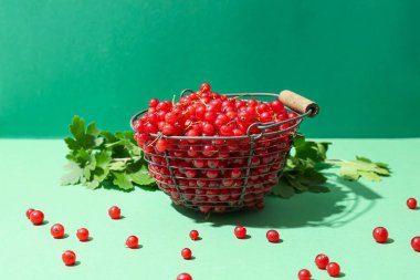 Taze kırmızı üzümlü sepet ve arka planda yapraklar