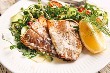 Lezzetli kızarmış morina filetosu ve sebze tabağı, yakın plan.