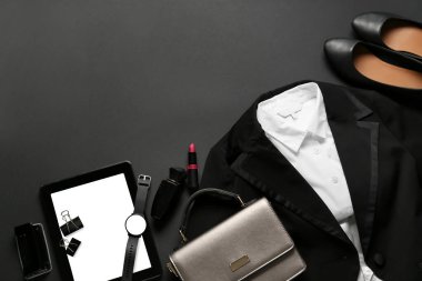 Koyu arkaplanda şık kadın giysileri, aksesuarlar ve tablet bilgisayar
