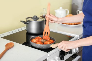 Kadın mutfakta köfte pişiriyor.