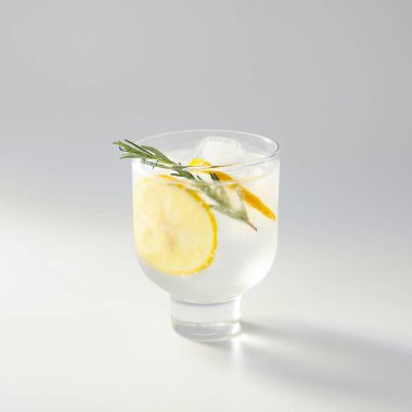 Beyaz arka planda bir bardak soğuk cin tonik.