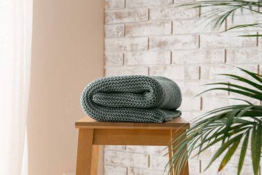 Tuğla duvarın yanında ekose örülmüş tabure