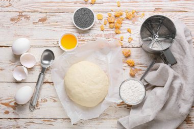 Haşhaş tohumu çöreği için taze hamur ve hafif ahşap arka planda malzemeler