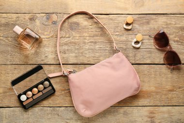Şık kadın aksesuarları ve ahşap arka planda dekoratif kozmetik.