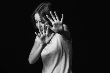 Karanlık arka planda korkmuş genç bir kadın. Taciz kavramı