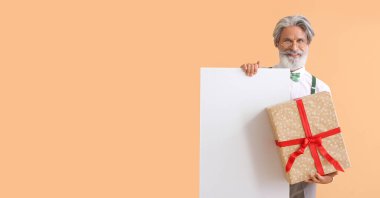 Renkli arka planda boş posteri ve hediyesi olan şık olgun bir adam.