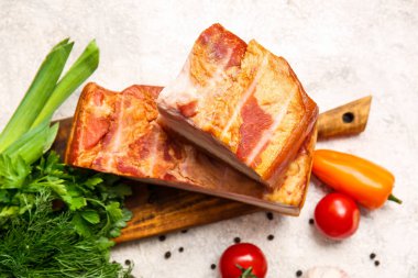 Hafif arka planda lezzetli tütsülenmiş pastırmalı ahşap tahta.