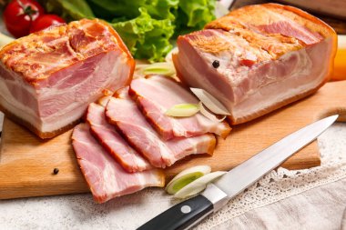 Hafif arka planda lezzetli tütsülenmiş pastırmalı ahşap tahta.