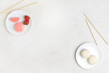 Lezzetli Japon mochi tabakları ve hafif arka planda çubuklar.