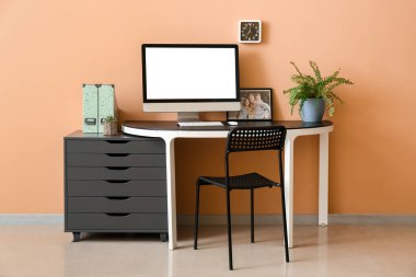 Renk duvarına yakın bilgisayarı olan modern işyeri