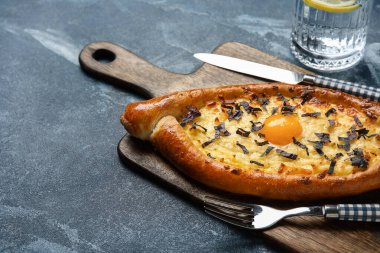 Renkli arka planda lezzetli Ajarian Khachapuri tahtası, yakın plan.