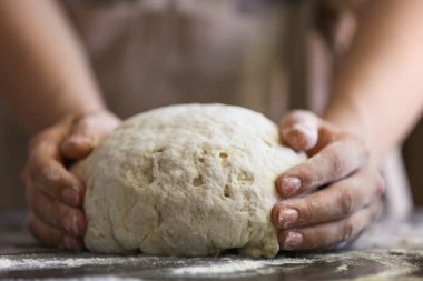 Kadın aşçı mutfak masasında hamur hazırlıyor, yakın plan.