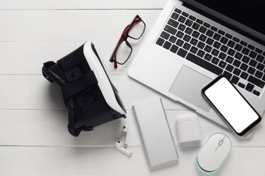 Hafif ahşap arka planda farklı modern cihazlar ve gözlük