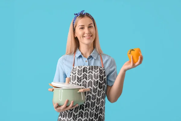 Junge Hausfrau Mit Topf Und Paprika Auf Farbigem Hintergrund — Stockfoto