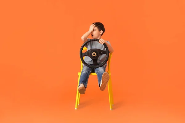 Malý Chlapec Volantem Sedí Křesle Barevném Pozadí — Stock fotografie